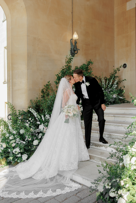 Olivia and Jack share a kiss on the flower-covered steps at Syon House