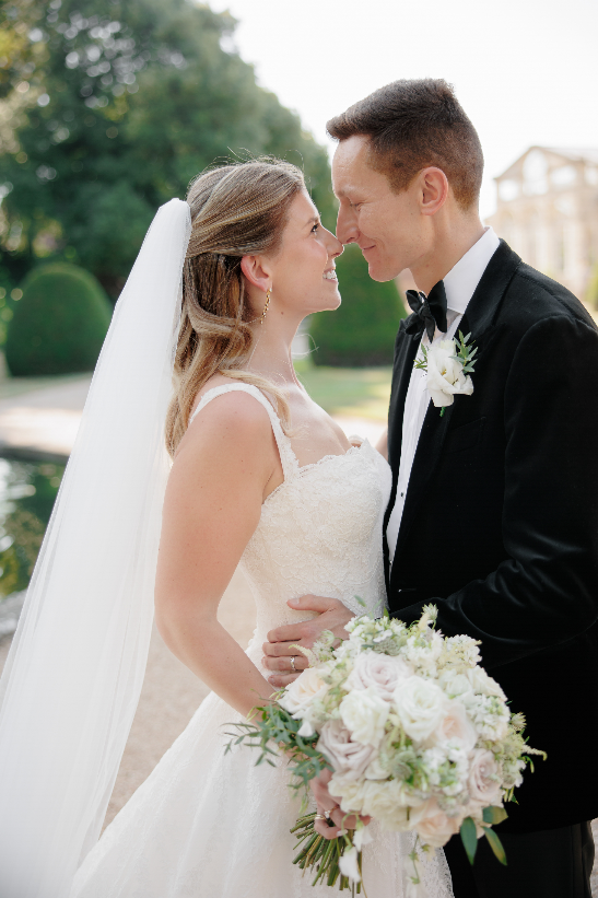 Olivia and Jack together on their wedding day, holding her ivory and blush bridal bouquet